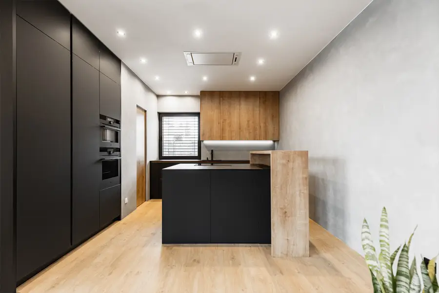Moderní černá kuchyně s dřevem a ostrůvkem